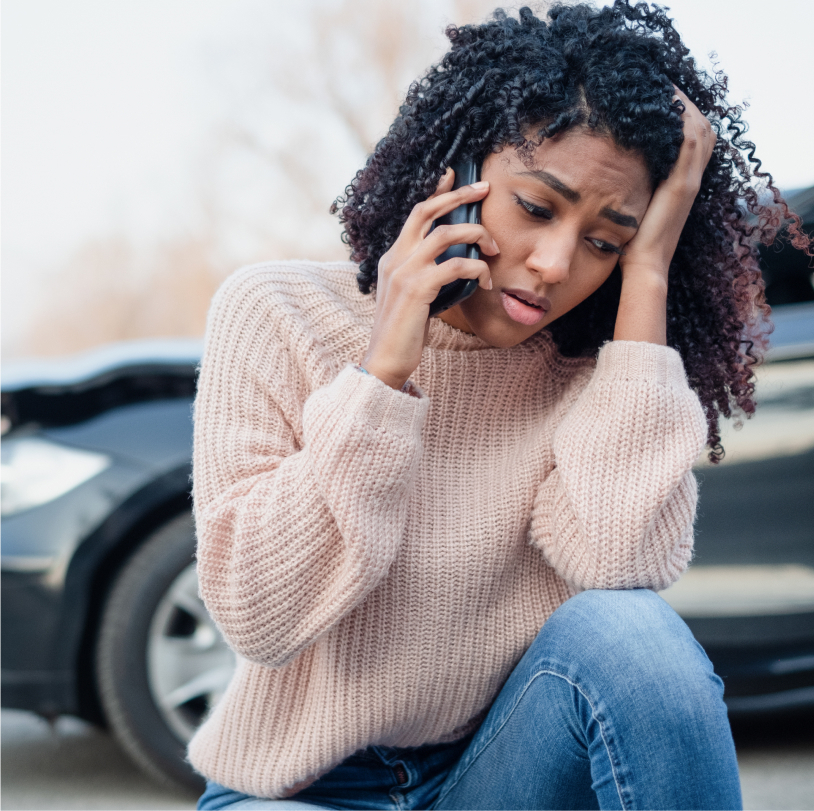 person upset on cell phone after car accident
